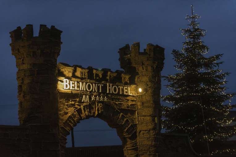 Belmont Hotel Arch at Nighttime with Christmas Tree