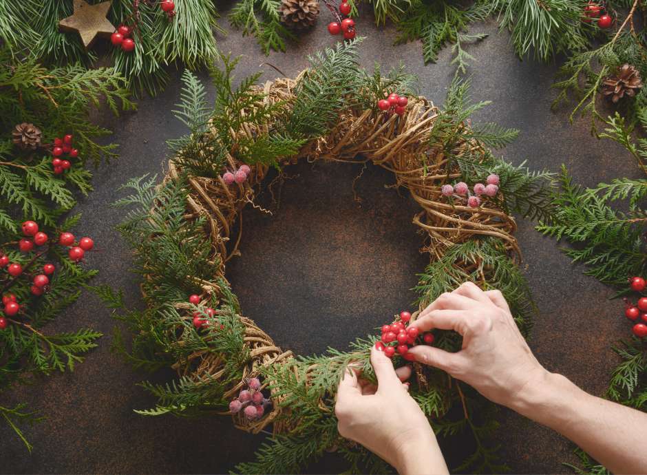 A pair of hands creating a festive wreath