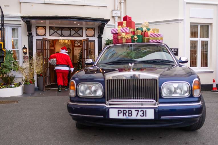 Santa Walking into the Belmont Hotel and Rolls Royce with Gifts on Roof 